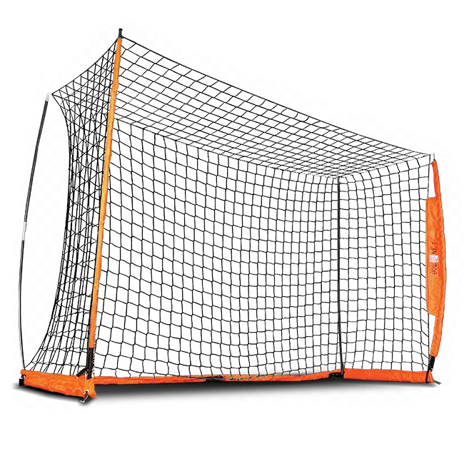 Kid in front of Aluminium soccer goal playig with a soccer ball. Orange and black portable soccer goal with girl playing football. 