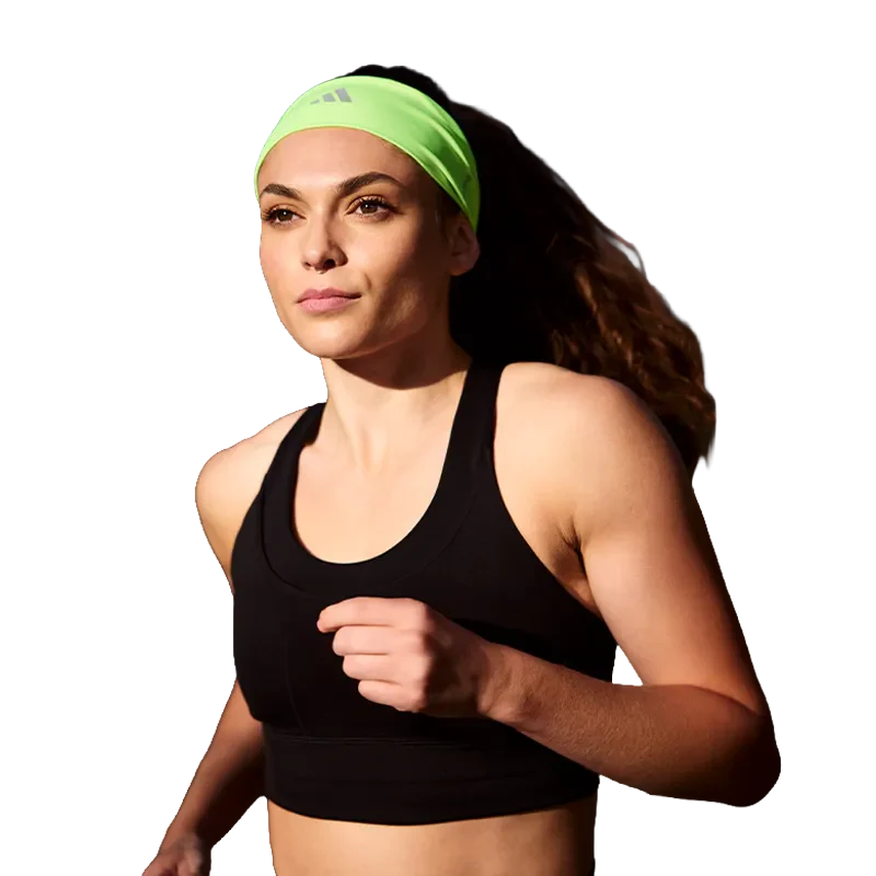 Female athlete tieing up her hear with adidas sports hairband and hair tie. Sports headwear, caps and hats.