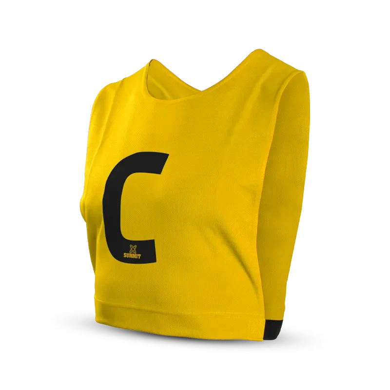 Netball player in Yellow Netball Bib with White Centre position. White C on Yellow netball bib for netball. 