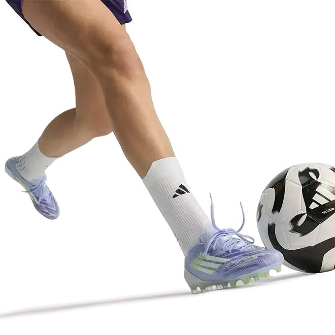 women in football boots kicking ball