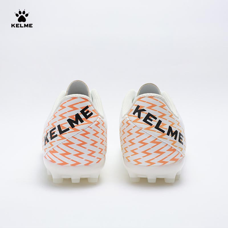 Back view of KELME Bolt Football Boots in white with orange pattern on heel