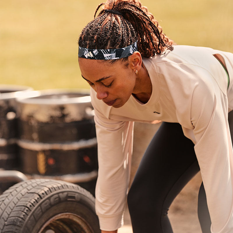 Person wearing a black adidas headband while lifting weights, designed for moisture-wicking and keeping sweat away during workouts.