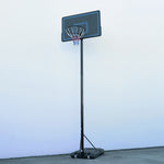 Basketball hoop with backboard on a stand against a light blue wall.