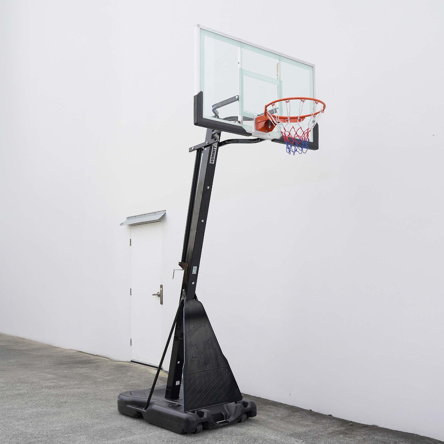 Basketball hoop with clear backboard against a white wall.