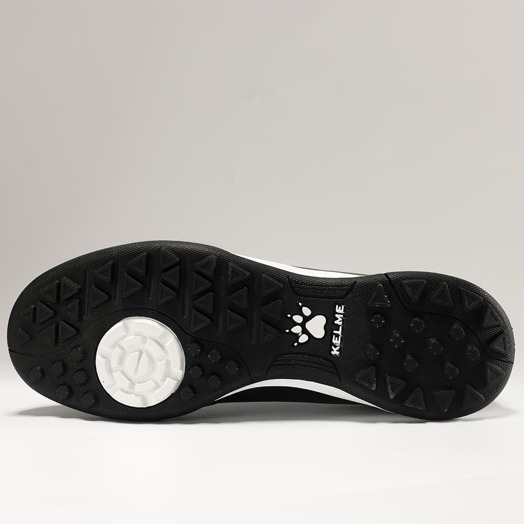 KELME Neo Sr Turf Boots for artificial surfaces - in black and white colour. View of studs on sole of shoe