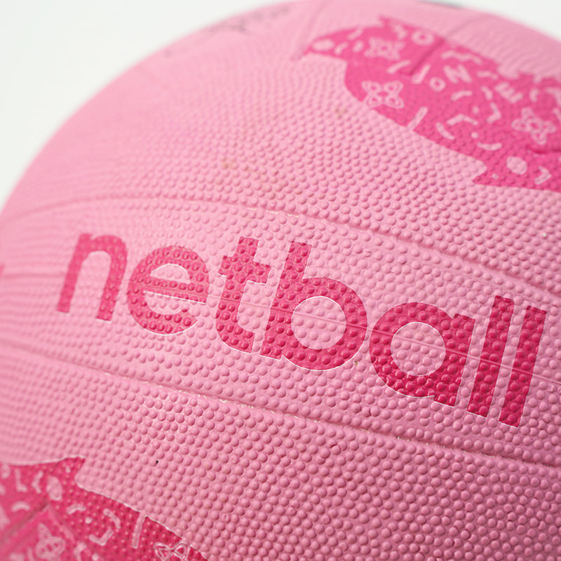 Close-up of a pink netball with 'netball' text on a white background
