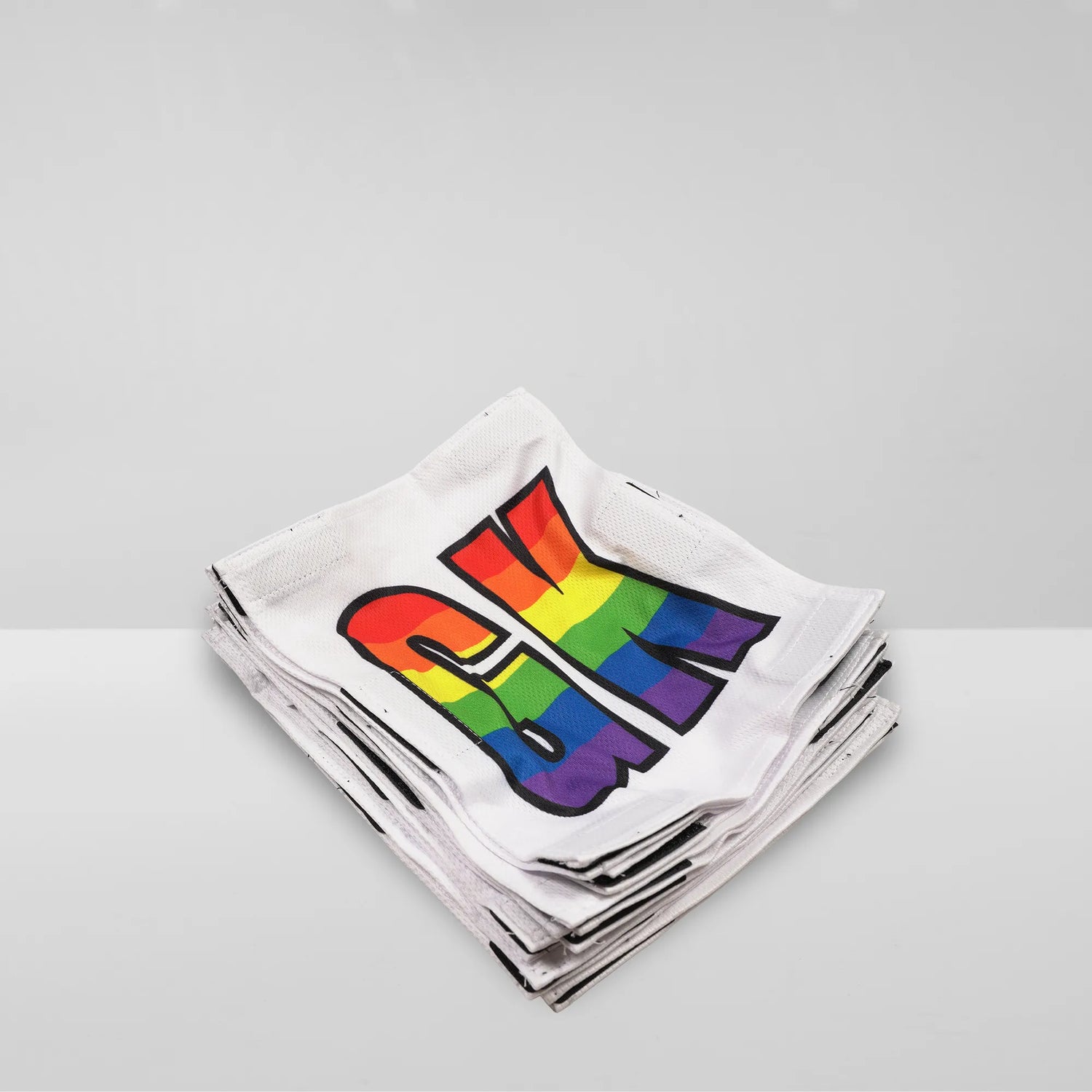 Stack of Netball dress team patches in white with rainbow printed positions