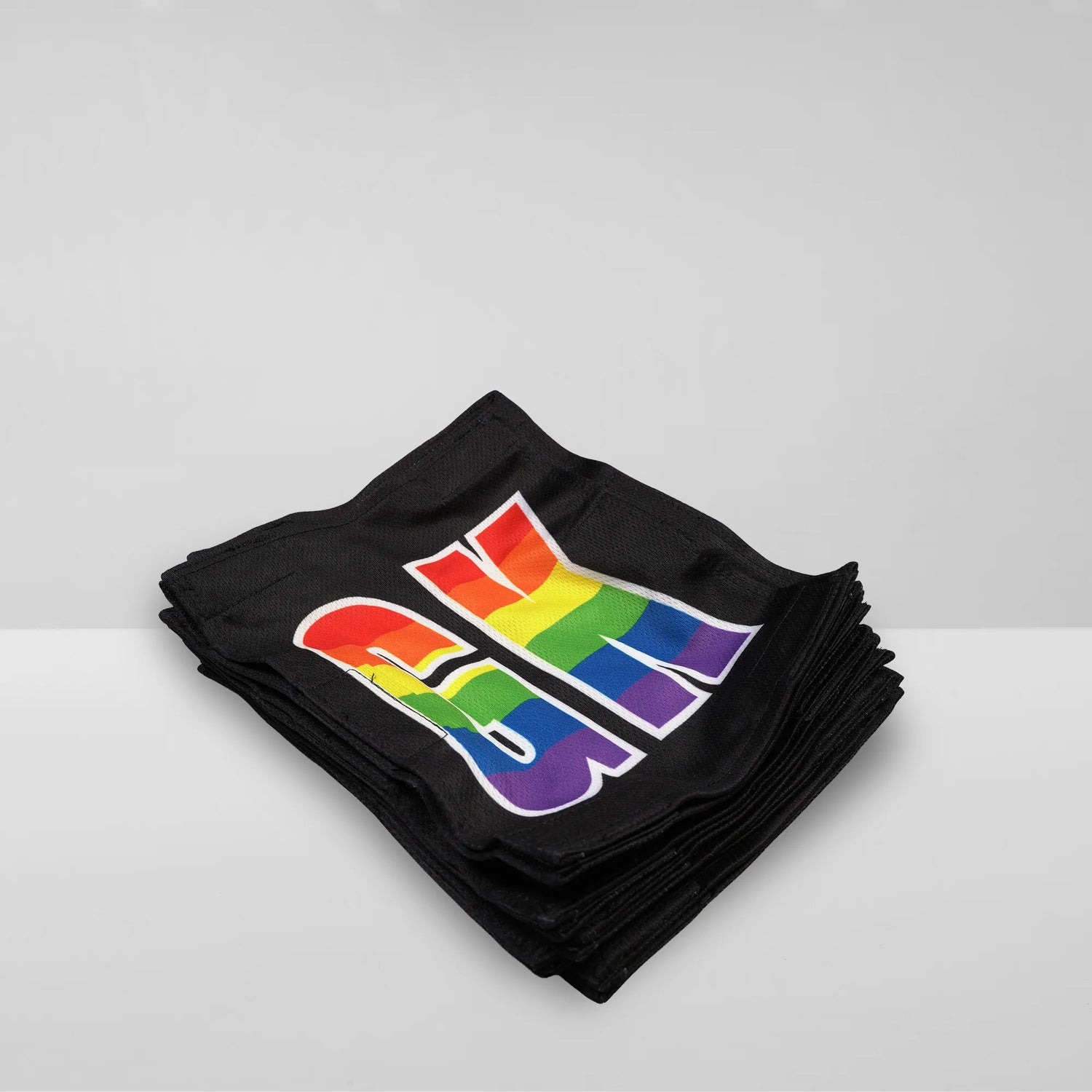 Stack of Netball dress team patches in black with rainbow printed positions