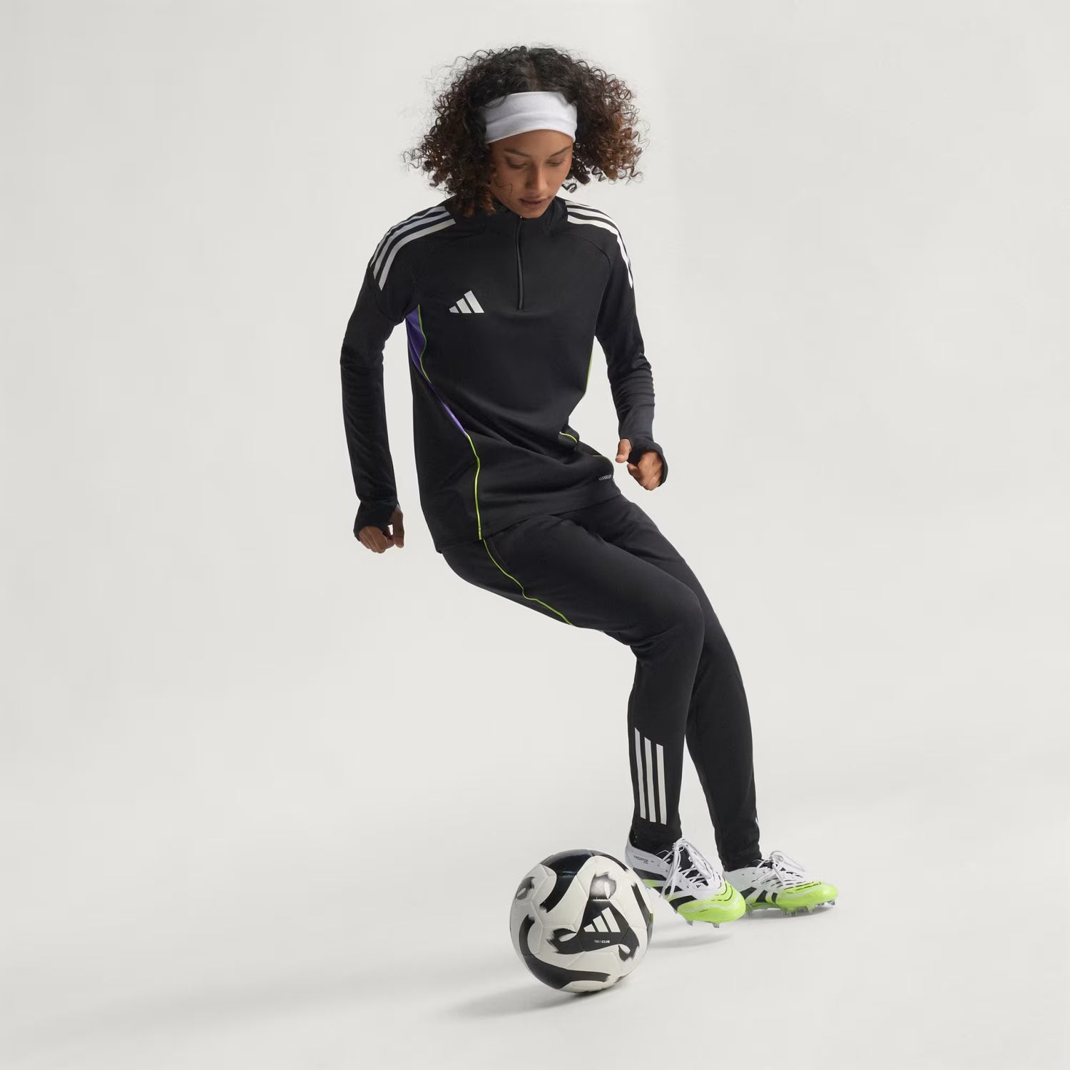 Person wearing an Adidas tracksuit with a soccer ball on a white background