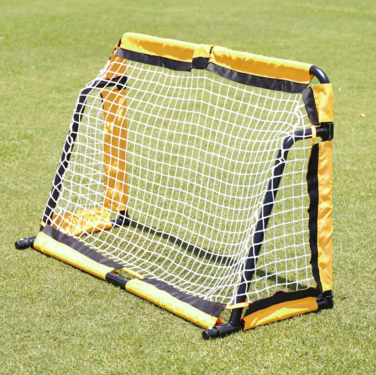 Back side of the SUMMIT Football Australia Yellow and black soccer goal on a grass field.