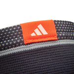Close up of adidas knee support showing orange label featuring adidas logo