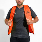 Safety bib for working, sports and high vis. Fluro orange open front mesh bib. Man closing mesh bib for safety.