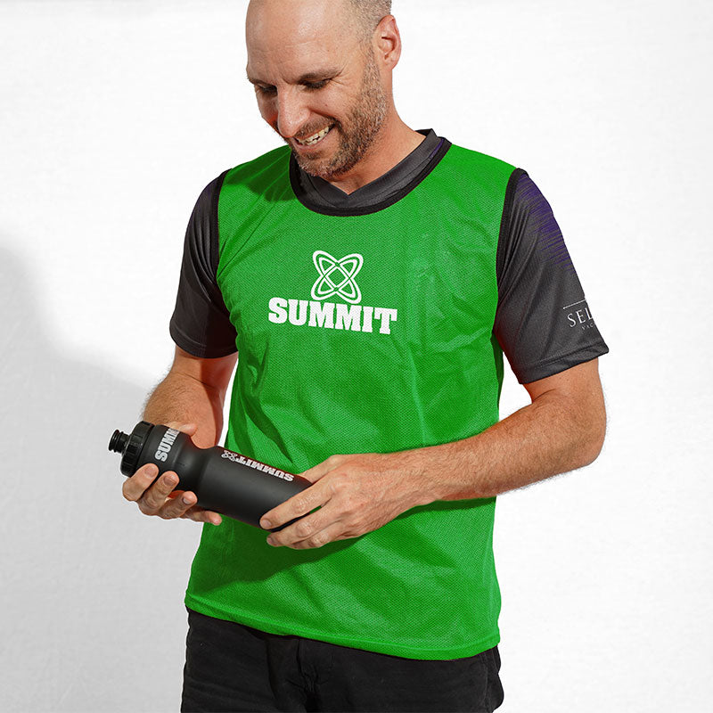 Man with green sports bib with SUMMIT logo on front. Sports mesh bib. 