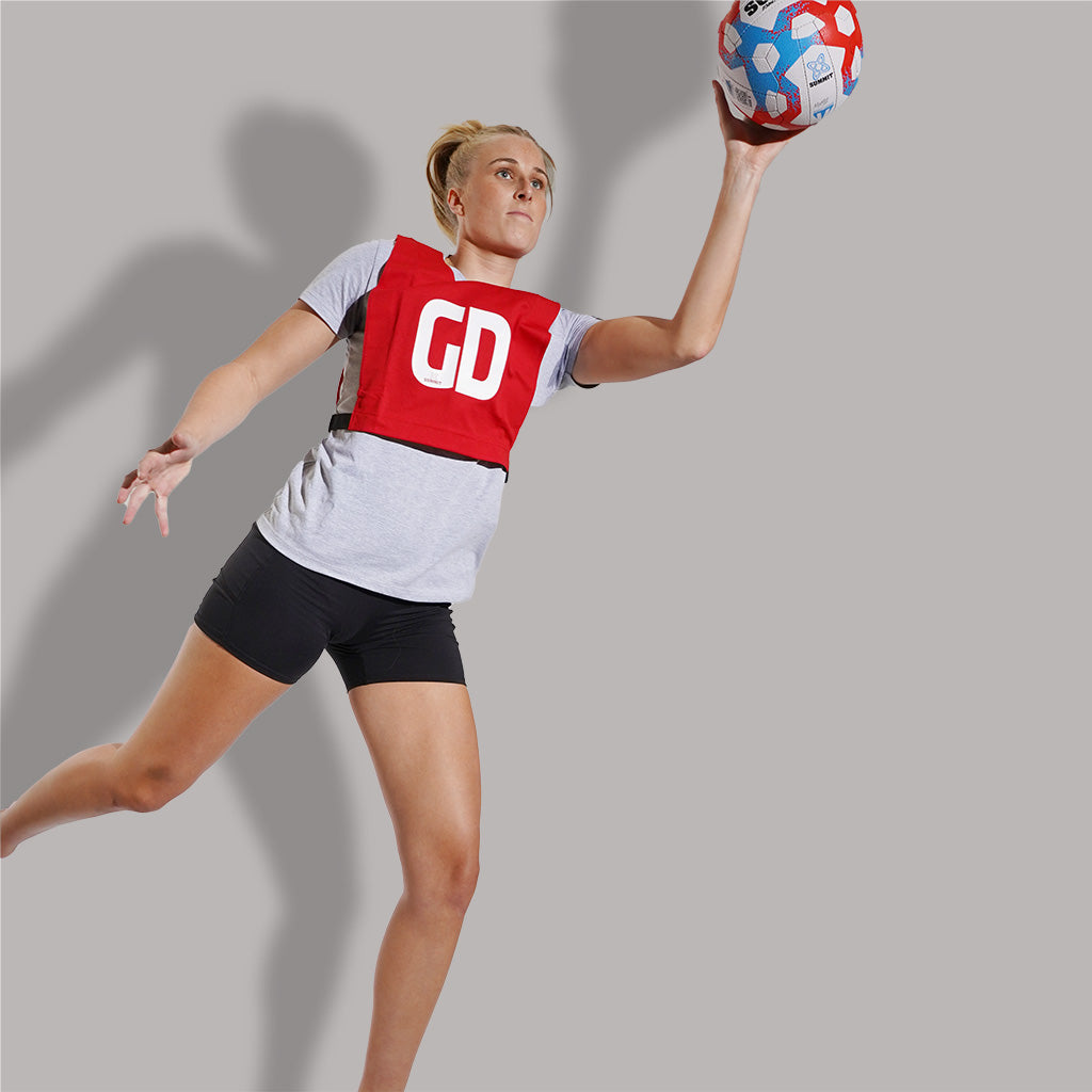 Maddy Turner playing netball in Red GD Netball Bib by SUMMIT Sport. 