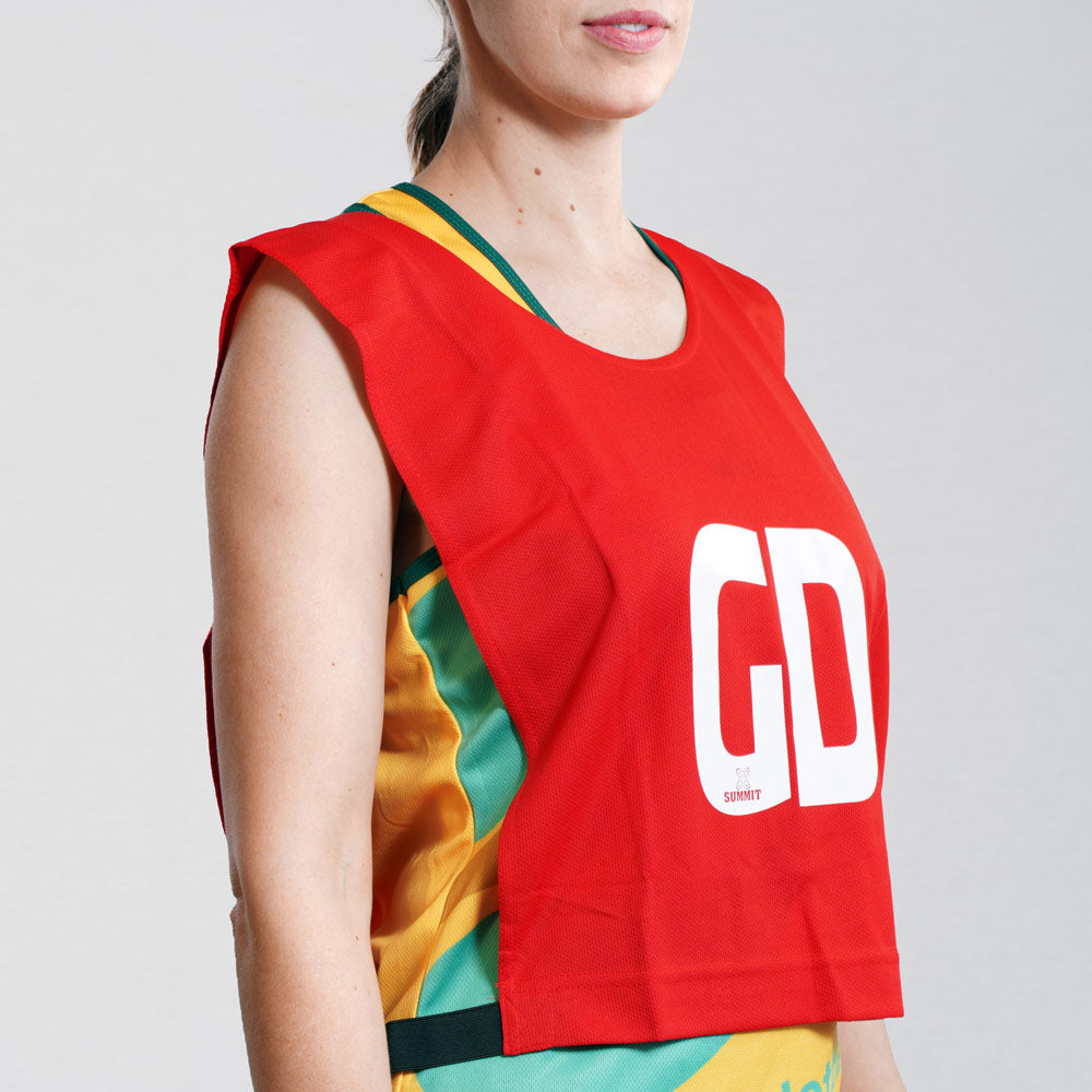 Goal Defence netball bib on young netball player. Red netball bib with elastic sides for easy fitment. Comes in a pack of 7 for netball teams