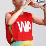 Netball bib being used by female netball player with SUMMIT Netball. Red Netball Bib for Wing Attack (WA) position. Shop netball bibs.