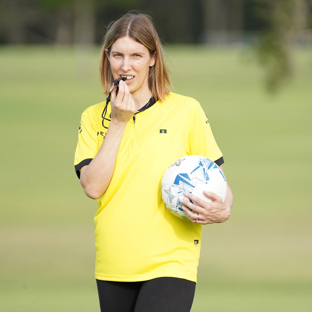 Female soccer coach blowing fox 40 whistle. Women holding soccer ball coaching football team is about to blow the whistle. 